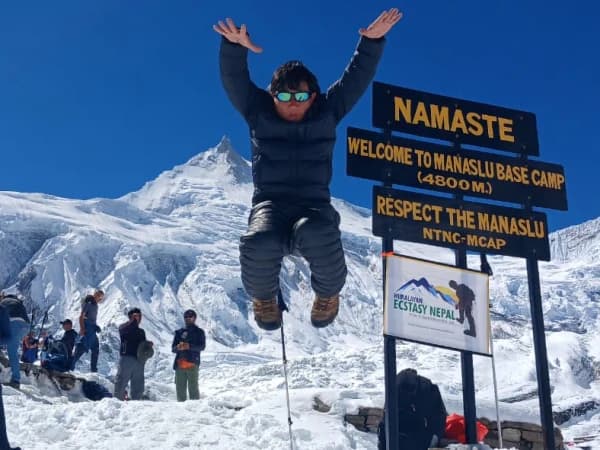 Guide Jumping At Manaslu Base Camp Sign